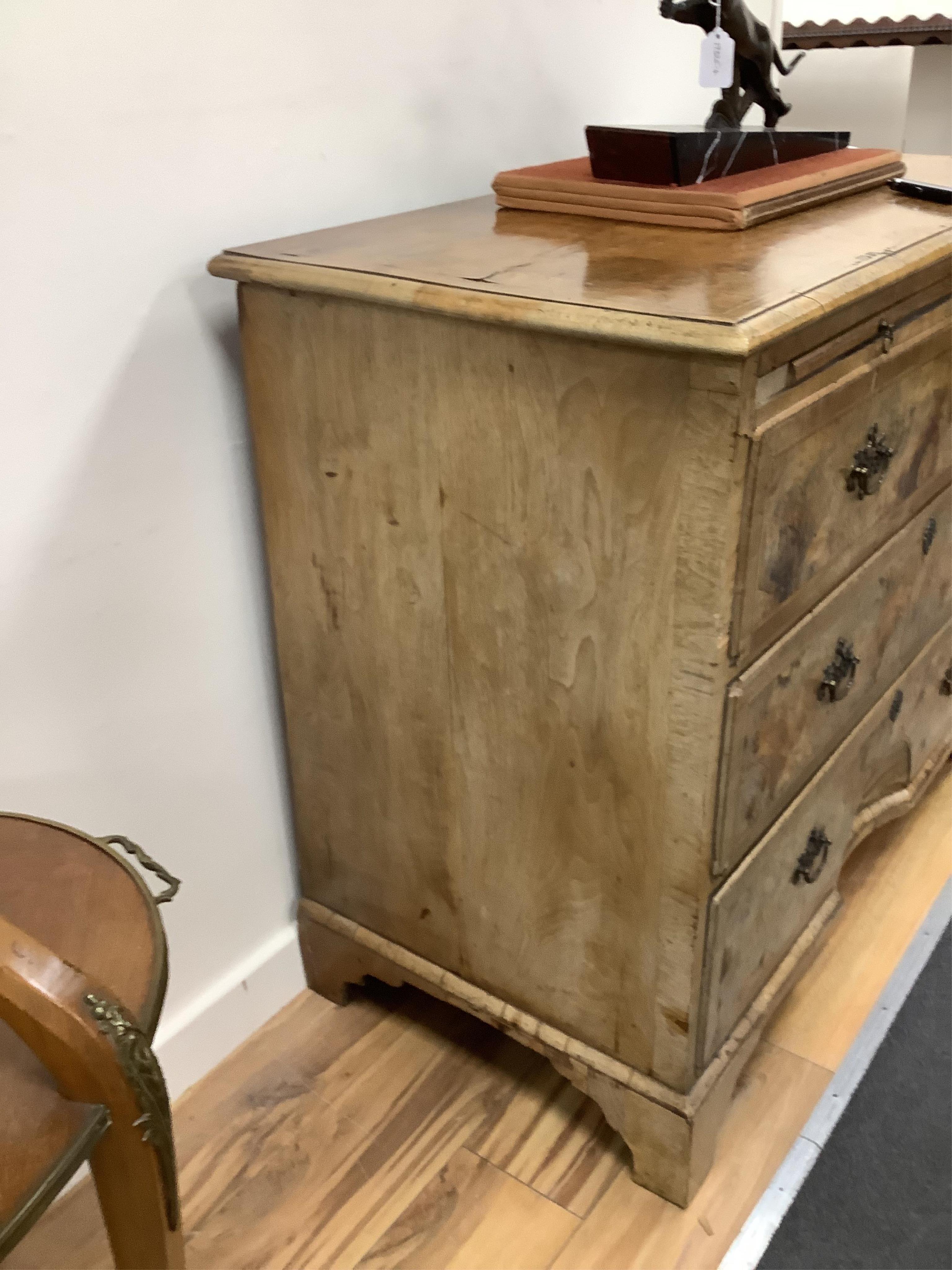A mid 18th century feather banded walnut concave starburst walnut chest of three drawers, with brushing slide, width 108cm, depth 54cm, height 92cm